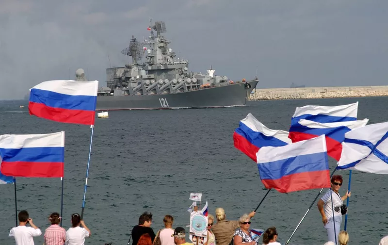 Pro-Russian supporters wave flags as they welcome missile cruiser Moskva, lagship of Russian Black Sea Fleet, as it enters Sevastopol bay on September 10, 2008. The missile cruiser Moskva (Moscow) returned to Sevastopol, Russia's Black Sea fleet base in the Ukrainian peninsula of Crimea, after participation in Russia's military operation in Georgia. AFP PHOTO/VASILY BATANOV (Photo by Vasily BATANOV / AFP)