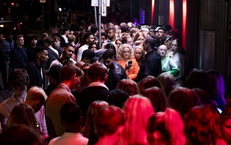 Nightlife guests crowd in front of the "Rumors" Nightclub on Noerregade street in Copenhagen during the night between September 2 and 3, 2021, as Denmark lifted restrictions amid the novel coronavirus / COVID-19 pandemic. - Denmark will lift all of its Covid-19 restrictions by September 10, health officials announced, saying the virus no longer posed "a threat to society" due to the country's broad vaccination coverage. (Photo by Olafur Steinar Gestsson / Ritzau Scanpix / AFP) / Denmark OUT