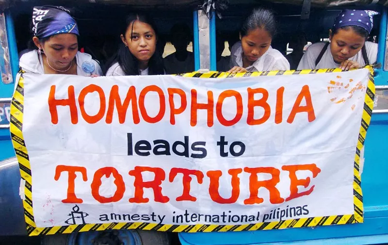 Leftist human rights activists stage a protest, citing homophobia as one of the causes of abuse in a rally in Manila 26 June 2004 to mark the International Day for Victims of Torture. The activists accused the government of President Gloria Arroyo of engaging in the torture of of various detainees.  AFP PHOTO Joel NITO