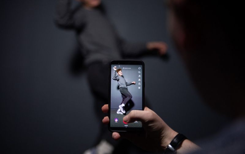 An AFP collaborator poses for a picture using the smart phone application TikTok on December 14, 2018 in Paris. - TikTok, is a Chinese short-form video-sharing app, which has proved wildly popular this year. (Photo by - / AFP)