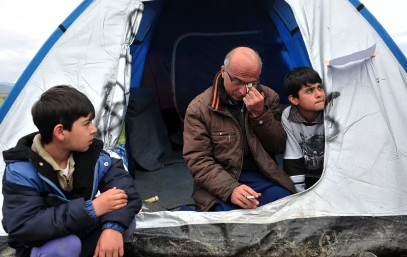 Nazim, a 44-year-old Syrian refugee and father of four, sits in a tent after he started a hunger strike while his wife is dying of cancer in a hospital in Germany, on March 12, 2016 at the Greek-Macedonian border near the Greek village of Idomeni where thousands of refugees and migrants are trapped by the Balkan border blockade. 
More than 14,000 mainly Syrian and Iraqi refugees including many children are camped out at the squalid camp where they have been stranded by Skopje's decision to close the frontier. Days of heavy rain have turned Greece's Idomeni border camp into a foul-smelling bog, exposing migrant children to raw sewage, noxious fumes and bitter cold, with aid workers describing conditions as "critical". / AFP / SAKIS MITROLIDIS / The erroneous mention appearing in the metadata of this photo by SAKIS MITROLIDIS has been modified in AFP systems in the following manner: IS DYING instead of DIED. Please immediately remove the erroneous mention from all your online services and delete it from your servers. If you have been authorized by AFP to distribute it to third parties, please ensure that the same actions are carried out by them. Failure to promptly comply with these instructions will entail liability on your part for any continued or post notification usage. Therefore we thank you very much for all your attention and prompt action. We are sorry for the inconvenience this notification may cause and remain at your disposal for any further information you may require.