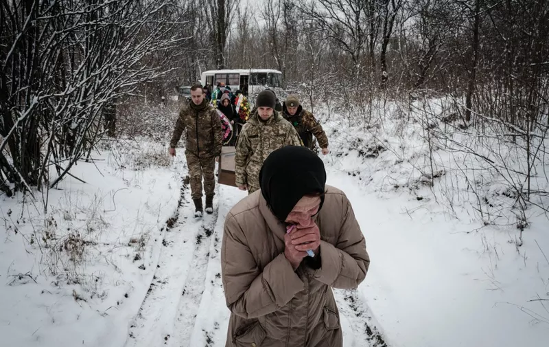 Natalia Shalashnaya (front), 52, who was a legal guardian of the late Ukrainian serviceman of the Azov battalion, 28-year-old orphan Oleksandr Korovniy, who was killed in action in Bakhmut, mourns as she attends a funeral procession for Korovniy at a cemetery in Sloviansk on January 30, 2023, amid the Russian invasion of Ukraine. (Photo by YASUYOSHI CHIBA / AFP)