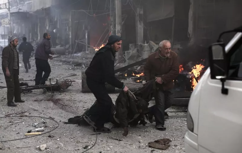 Syrian men carry a victim following reported air strikes by government forces in the town of Jisreen in the rebel-held region of Eastern Ghouta, on the outskirts of the capital Damascus, on December 4, 2015. At least 35 civilians were killed and dozens wounded in a series of Syrian regime raids on the rebel stronghold east of Damascus, the Syrian Observatory for Human Rights said. AFP PHOTO / AMER ALMOHIBANY / AFP / AMER ALMOHIBANY