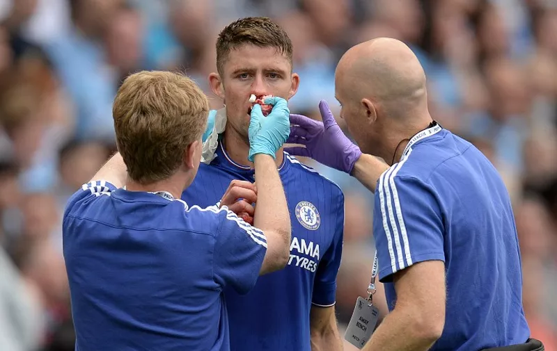 Chelsea's English defender Gary Cahill is attended to by Chelsea medical staff, Chris Hughes (L) and Steven Hughes (R) during the English Premier League football match between Manchester City and Chelsea at The Etihad stadium in Manchester, north west England on August 16, 2015. AFP PHOTO / OLI SCARFF

RESTRICTED TO EDITORIAL USE. No use with unauthorized audio, video, data, fixture lists, club/league logos or 'live' services. Online in-match use limited to 75 images, no video emulation. No use in betting, games or single club/league/player publications.
