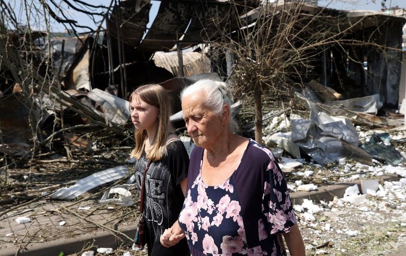 Two person walk among the debris of a destroyed local market after a Russian missile strike in the town of Bakhmut, Donetsk region on July 16, 2022 amid Russian military invasion of Ukraine. (Photo by Anatolii Stepanov / AFP)