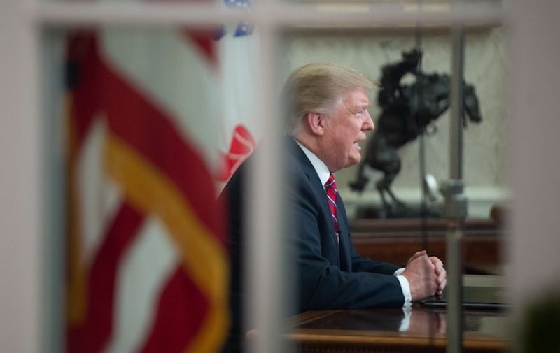 US President Donald Trump delivers a televised address to the nation on funding for a border wall from the Oval Office of the White House in Washington DC on January 8, 2019. - Trump demanded $5.7 billion to fund a wall on the US-Mexico border in his first televised Oval Office address Tuesday, describing a "growing crisis" of illegal immigration hurting millions of Americans. The president stopped short of calling for a much-touted state of emergency, instead appealing to the need to slash the cost of the illegal drug trade, which he put at $500 billion a year. "There is a growing humanitarian and security crisis at our southern border. Every day customs and border patrol agents encounter thousands of illegal immigrants trying to enter our country," Trump said. (Photo by SAUL LOEB / AFP)