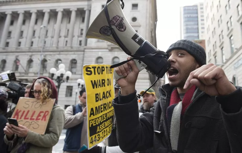 Protesters react outside Baltimore City Circuit Courthouse after the hung-jury was announced in the trial of Police Officer William Porter, in Baltimore, Maryland on December 16, 2015. The manslaughter trial of a Baltimore policeman accused over the death in custody of African-American Freddie Gray was declared a mistrial after the jury failed to a reach a verdict, putting the city on edge. AFP PHOTO/ MOLLY RILEY / AFP / MOLLY RILEY