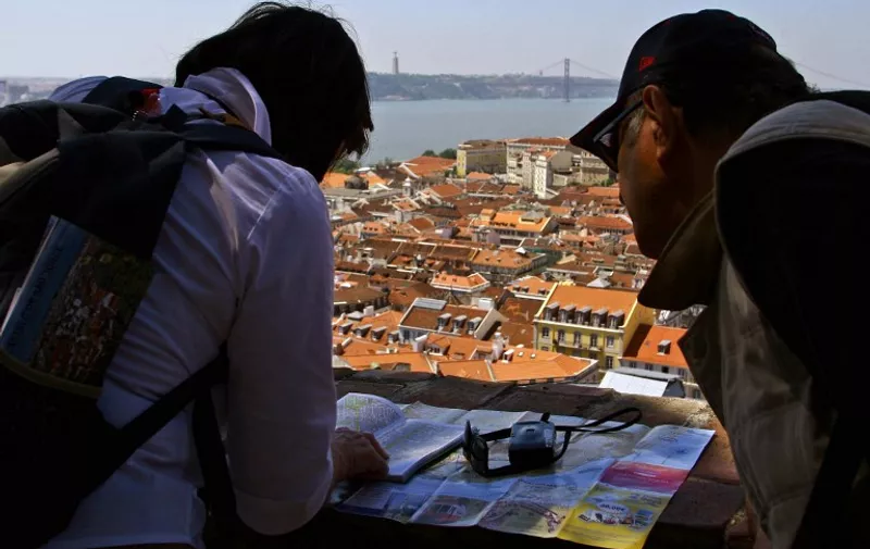 Tourists look at a map of Lisbon in Sao Jorge Castle in Lisbon 29 April 2006. Lisbon, which has become a fashionable tourist destination since the end of the '90s, seeks to compete with Barcelona to become the favorite tourist spot of the Iberian peninsula, according to the officials at the city's tourism association.  AFP PHOTO/ FRANCISCO LEONG
