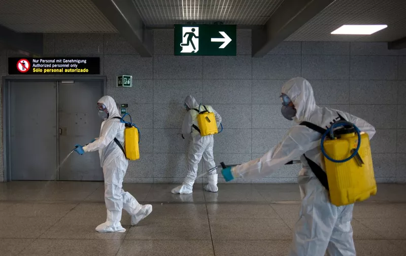 Members of the Military Emergencies Unit (UME) carry out a general disinfection at Malaga airport on March 16, 2020. - Spain has registered nearly 1,000 new COVID-19 infections over the past 24 hours, raising the total number of cases to 8,744. In order to rein in the virus, Spain has declared a state of alert, shutting all but essential services and ordering its population of 46 million people to stay at home. People are only authorised to go out to buy food or medicine, to go to work or to get medical treatment. (Photo by JORGE GUERRERO / AFP)