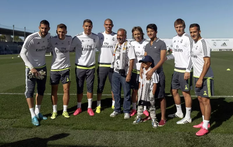 Osama Abdul Mohsen (C), the Syrian refugee who made world headlines when a Hungarian journalist tripped him over as he fled, and his sons Mohammad (3rdR) and Zaid (3rdR front) pose with (FromL) Real Madrid players, goalkeeper Kiko Casilla, Russian midfielder Denis Cheryshev, Portuguese forward Cristiano Ronaldo, Portuguese defender Pepe, Croatian midfielder Luka Modric, German midfielder Toni Kroos and midfielder Lucas during a training session at Valdebebas training ground in Madrid on September 18, 2015. Video footage of journalist Petra Laszlo tripping Mohsen onto the grass as he ran with his son Zaid in his arms near the Hungary-Serbia border sparked outrage this month. She was fired from the television channel she worked for.   AFP PHOTO/ HO/ REAL MADRID/ HELIOS DE LA RUBIA

RESTRICTED TO EDITORIAL USE - MANDATORY CREDIT "AFP PHOTO/ HO/ REAL MADRID/ HELIOS DE LA RUBIA" NO MARKETING NO ADVERTISING CAMPAIGNS - DISTRIBUTED AS A SERVICE TO CLIENTS