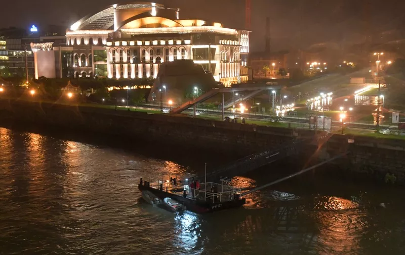 A victim's body is covered by a black plastic at Danube River close to the National Theatre of  Budapest on May 29, 2019. - A river boat used for tourism capsized in the Hungarian capital on May 29, 2019 with dozens of people on board, and a rescue effort was underway as 3 people died and 16 others missing. (Photo by GERGELY BESENYEI / AFP)