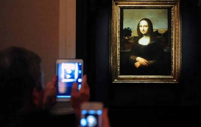 Members of the media take pictures during the media preview of The World Premiere of Leonardo Da Vinci's painting "Earlier Mona Lisa" exhibition in Singapore on December 15, 2014. The World Premiere of Leonardo Da Vinci's exhibition will begin on December 16 till February 1, 2015. AFP PHOTO / MOHD FYROL RESTRICTED TO EDITORIAL USE, MANDATORY MENTION OF THE ARTIST UPON PUBLICATION, TO ILLUSTRATE THE EVENT AS SPECIFIED IN THE CAPTION.