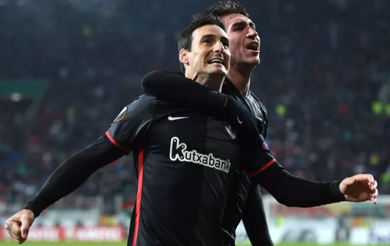 Bilbao's striker Aritz Aduriz (L) and Bilbao's French defender Aymeric Laporte (R) celebrate scoring during the UEFA Europa League football match FC Augsburg v Athletic Club in Augsburg, southern Germany on November 26, 2015. AFP PHOTO / CHRISTOF STACHE / AFP / CHRISTOF STACHE