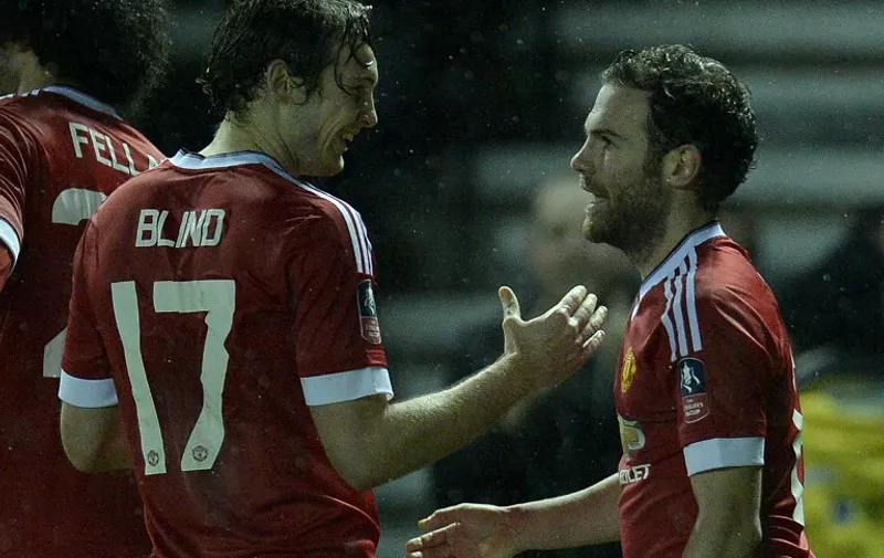 Manchester United's Dutch midfielder Daley Blind (L) congratulates Manchester United's Spanish midfielder Juan Mata for scoring the team's third goal during the FA cup fourth round football match between Derby County and Manchester United at Pride Park stadium in Derby on January 29, 2016.
Manchester United won the match 3-1. / AFP / OLI SCARFF / RESTRICTED TO EDITORIAL USE. No use with unauthorized audio, video, data, fixture lists, club/league logos or 'live' services. Online in-match use limited to 75 images, no video emulation. No use in betting, games or single club/league/player publications.  /