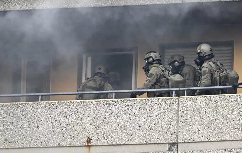 Special police forces enter amid smoke an appartment of a high-rise building, on May 11, 2023 in Ratingen, western Germany, after an explosion occured in which several people were injured including police officers . (Photo by Roberto Pfeil / AFP)