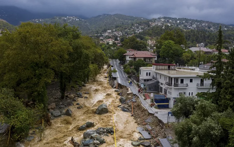 An aerial view taken on September 6, 2023 shows a partially destroyed road in a flooded area in the city of Volos, central Greece. The regional capital Volos has seen 200 millimetres (about eight inches) of rain, while 600 mm have fallen in the neighbouring village of Zagora, according to the National Meteorological Service (EMY). At least one person died in eastern Greece after torrential rains hit the country, already ravaged for weeks by devastating wildfires, authorities said on September 5, 2023. (Photo by STRINGER / Eurokinissi / AFP)