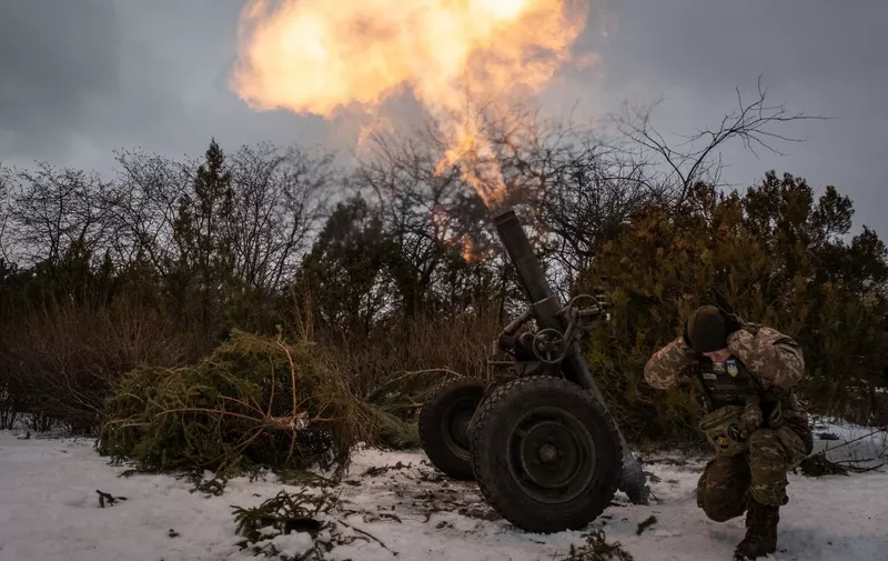 A Ukrainian serviceman of the 93rd brigade covers his ears while firing a French 120mm rifled towed mortar (designated as a MO-120-RT-61) towards Russian positions in Bakhmut on February 15, 2023, amid the Russian invasion of Ukraine. (Photo by YASUYOSHI CHIBA / AFP)