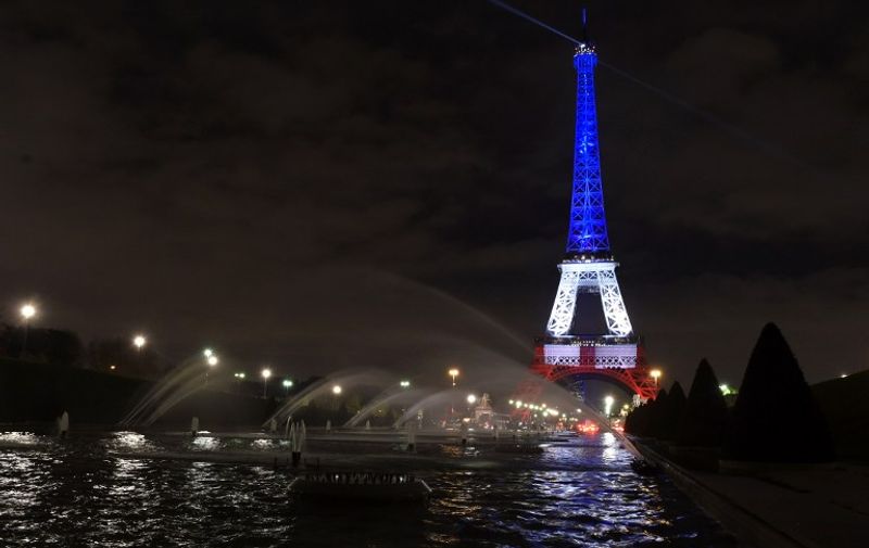 A photo taken on November 16, 2015 in Paris shows the Eiffel Tower illuminated with the colors of the French flag in tribute to the victims of the November 13, 2015 Paris terror attacks. AFP PHOTO / ALAIN JOCARD