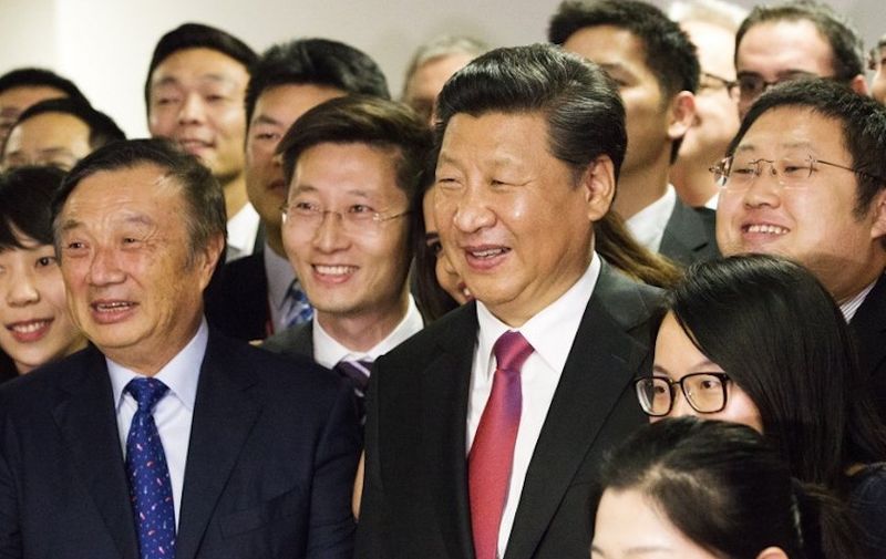 Chinese President Xi Jinping (C) poses with Huawei technologies President Ren Zhengfei (L) and members of staff as he is shown around the offices of the Chinese tech firm in London during his state visit on October 21, 2015. 
AFP PHOTO / POOL / Matthew Lloyd (Photo by MATTHEW LLOYD / POOL / AFP)