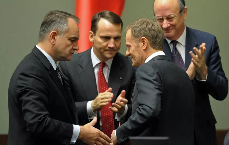 Deputy prime Minister Waldemar Pawlak (L), Foreign Minister Radoslaw Sikorski (2nd L) and Minister of Finance Jan Vincent-Rostowski (R) applaud Poland's Prime Minister Donald Tusk after his address to parliament in Warsaw, on November 18, 2011. Polish President Bronislaw Komorowski approved a new government line-up proposed by centrist Prime Minister Donald Tusk, who won an historic second term in last month's general election. AFP PHOTO / JANEK SKARZYNSKI (Photo by JANEK SKARZYNSKI / AFP)
