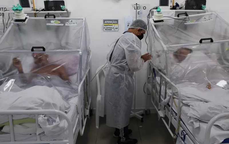 (FILES) In this file photo taken on May 20, 2020 a health worker is seen next to patients in the Intensive Care Unit for COVID-19 of the Gilberto Novaes Hospital in Manaus, Brazil. - The Brazilian city of Manaus, which was devastated by the coronavirus pandemic, may have suffered so many infections that its population now benefits from "herd immunity," according to a preliminary study released on September 23, 2020. (Photo by MICHAEL DANTAS / AFP)