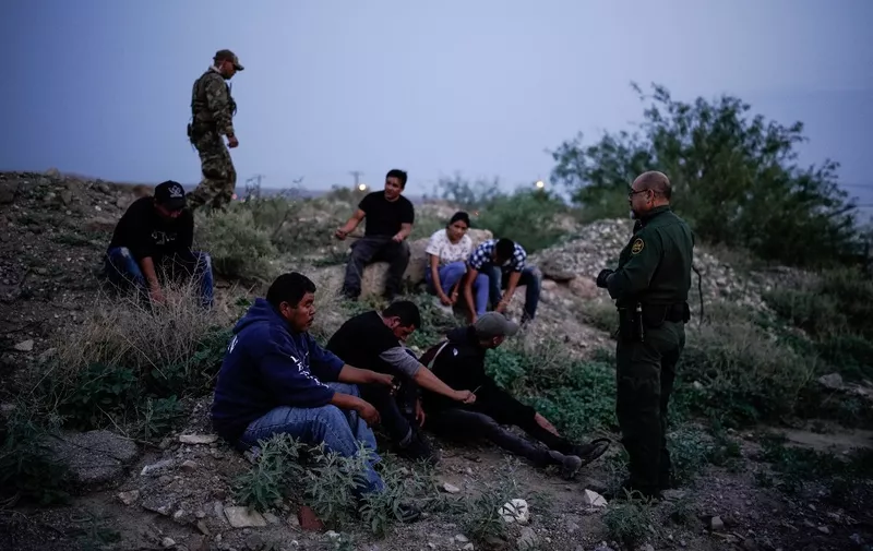 A US Border Patrol agent processes a group of migrants in Sunland Park, New Mexico on July 22, 2021. - Many advocates from national organizations urge President Biden to end Title 42 expulsions, a public health order issued in March 2020 by the Centers for Disease Control and Prevention to prevent the cross-border spread of Covid-19 resulting of hundreds of thousands of migrants expelled within hours of detention and therefore deny the opportunity to state their case for staying in the country. (Photo by PAUL RATJE / AFP)