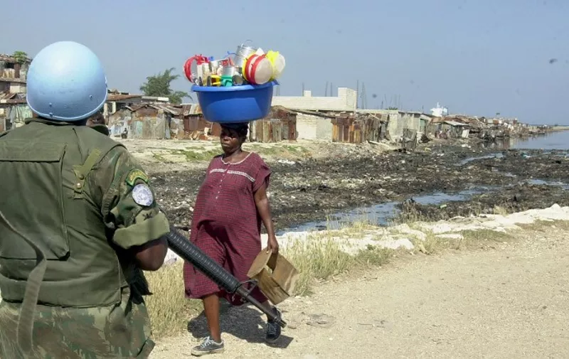 A soldier from the UN peacekeeping force patrols the Cite Soleil slum during a visit by New York Mayor Michael Bloomberg 27 July 2004 in the Haitian capital.   AFP PHOTO/Thony BELIZAIRE