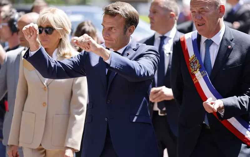 France's President Emmanuel Macron waves flanked by  Touquet's mayor Daniel Fasquelle as he leaves after voting in French parliamentary elections at a polling station in Le Touquet, northern France on June 12, 2022. (Photo by Ludovic MARIN / POOL / AFP)