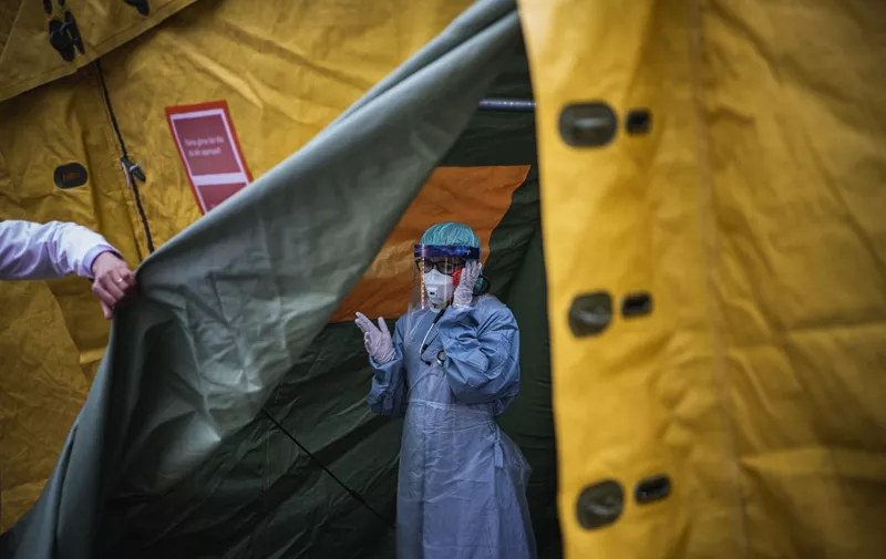A medical staffer at Sophiahemmet hospital talks on a cell phone inside a tent for testing and receiving potential coronavirus COVID-19 patients on April 7, 2020 in Stockholm. - Sweden on April 7, 2020 reported another 114 coronavirus deaths, bringing the total to 591 in a country that has adopted a softer approach to containing the outbreak than some of its European neighbours. (Photo by Jonathan NACKSTRAND / AFP)