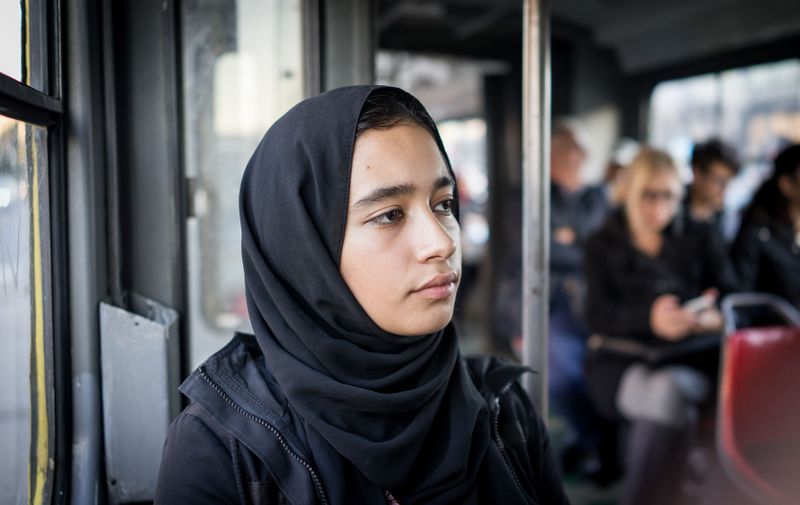 Middle Eastern girl riding public transport in city,Image: 501561167, License: Royalty-free, Restrictions: , Model Release: yes