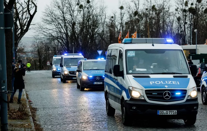 Police vehicles escort the transportation of defendants towards the Higher Regional Court in Dresden, eastern Germany on January 28, 2022 prior to the start of the trial over a jewellery heist on the Green Vault (Gruenes Gewoelbe) museum in Dresden's Royal Palace in November 2019. - Six members of a notorious criminal gang, aged 22 to 28, go on trial in Germany on January 28 over the spectacular heist in which 18th-century jewels were snatched from the state museum in Dresden. They are accused of gang robbery and arson after the brazen night raid on The Green Vault museum on November 25, 2019. (Photo by JENS SCHLUETER / AFP)
