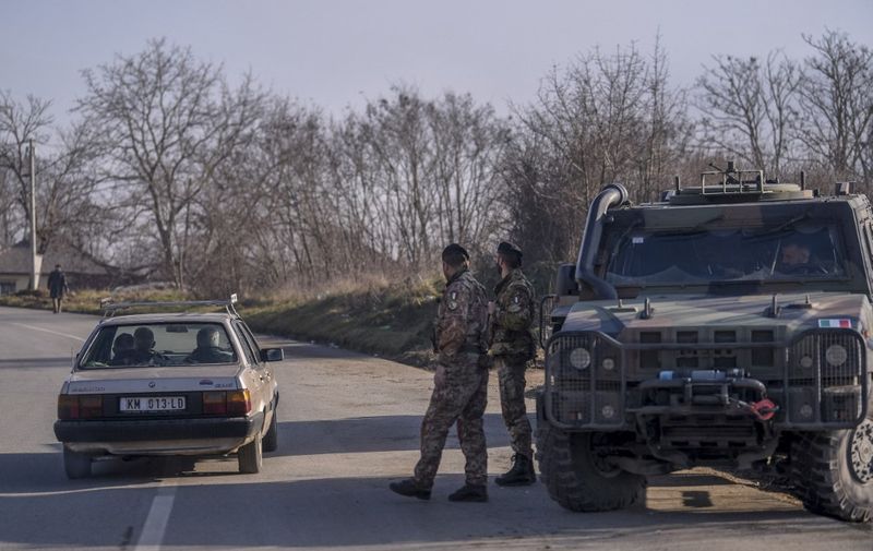 Italian soldiers serving in a NATO-led international peacekeeping mission in Kosovo patrol near a road barricaded with trucks by Serbs in the village of Rudare near the town of Zvecan on December 26, 2022. (Photo by Armend NIMANI / AFP)