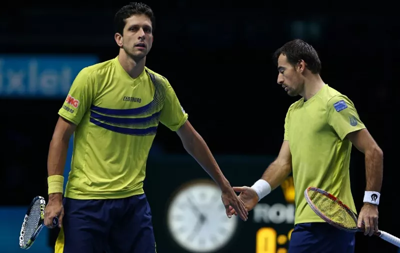 Croatia's Ivan Dodig (R) and Brazil's Marcelo Melo reacts against  Netherland's Jean-Julien Rojer and Romania's Horia Tecau during their men's doubles group stage match on day four of the ATP World Tour Finals tennis tournament in London on November 18, 2015.    AFP PHOTO / JUSTIN TALLIS