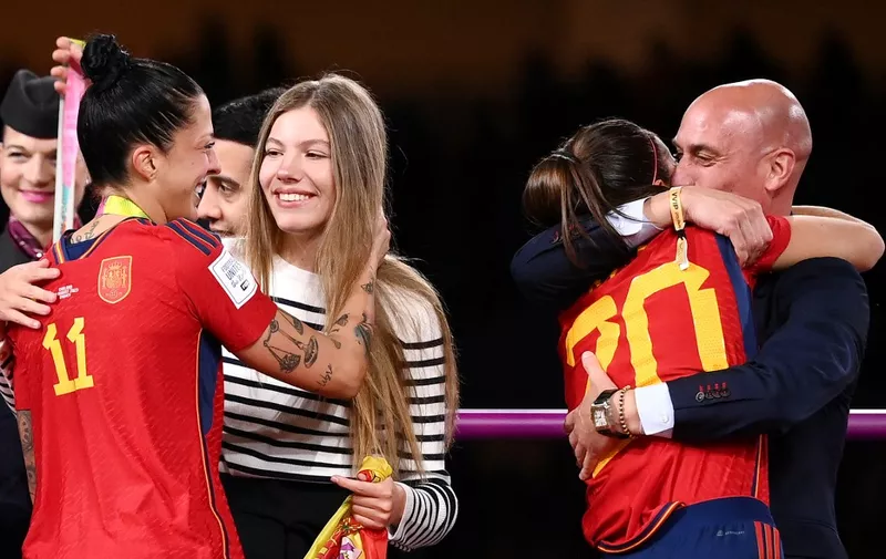 Spain's defender #20 Rocio Galvez is congratuled by President of the Royal Spanish Football Federation Luis Rubiales (R) next to Spain's Jennifer Hermoso after winning the Australia and New Zealand 2023 Women's World Cup final football match between Spain and England at Stadium Australia in Sydney on August 20, 2023. The Spanish football federation (RFEF) on August 26, 2023 threatened to take legal action over Women's World Cup player Jenni Hermoso's "lies" about her kiss with its president Luis Rubiales. (Photo by FRANCK FIFE / AFP)