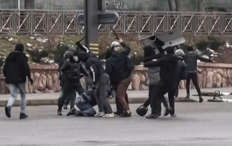 A frame grab taken on January 6, 2022 from an AFPTV video made on January 5, 2022, shows protesters clashing with Kazakstan's security forces during a demonstration in the country largest city Almaty as unprecedented unrest in the Central Asian nation spins out of control due to a hike in energy prices. - Protestors took from police officers gears and tear gas during a demonstration in the streets of Almaty that caused the death of twelve security officers and wounded 353 people, media reports said on January 6, 2022. Long seen as one the most stable of the ex-Soviet republics of Central Asia, energy-rich Kazakhstan is facing its biggest crisis in decades after days of protests over rising fuel prices escalated into widespread unrest. (Photo by Alexander PLATONOV / AFPTV / AFP)