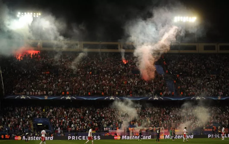Benfica supporters lit flares during the UEFA Champions League football match Club Atletico de Madrid vs SL Benfica at the Vicente Calderon stadium in Madrid on September 30, 2015.    AFP PHOTO/ PEDRO ARMESTRE