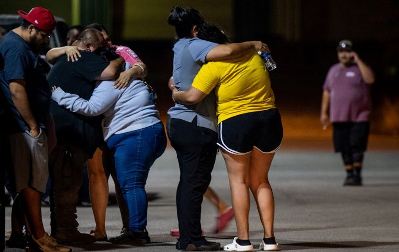 UVALDE, TEXAS - MAY 24: A family grieves outside of the SSGT Willie de Leon Civic Center following the mass shooting at Robb Elementary School on May 24, 2022 in Uvalde, Texas. According to reports, 19 students and 2 adults were killed, with the gunman fatally shot by law enforcement.   Brandon Bell/Getty Images/AFP (Photo by Brandon Bell / GETTY IMAGES NORTH AMERICA / Getty Images via AFP)