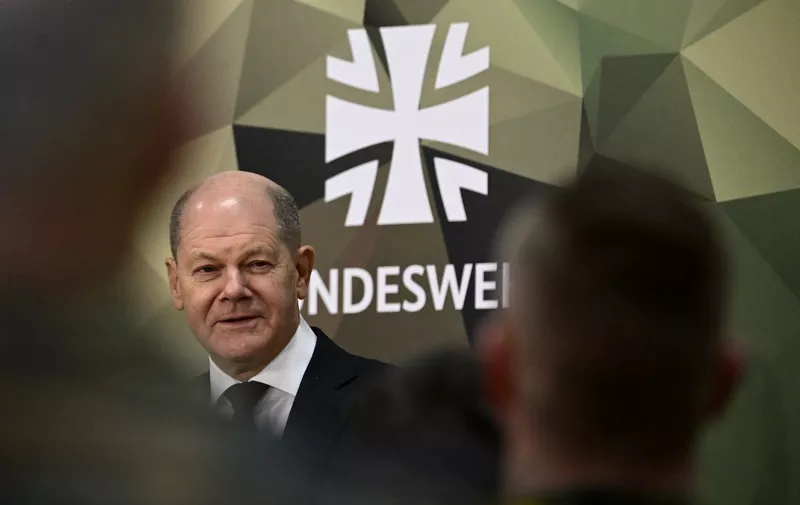 German Chancellor Olaf Scholz is pictured next to the Bundeswehr logo as he  addresses military personnel as part of his first visit to the Territorial Command of the German Armed Forces Bundeswehr at the Julius Leber Barracks in Berlin, Germany on February 28, 2023. - The new command was set up in September 2022 and is responsible for the management and coordination of Bundeswehr operations in Germany - from homeland security to coordinating the deployment of our own or allied troops to setting up a crisis management team in the Chancellery. (Photo by Tobias SCHWARZ / AFP)