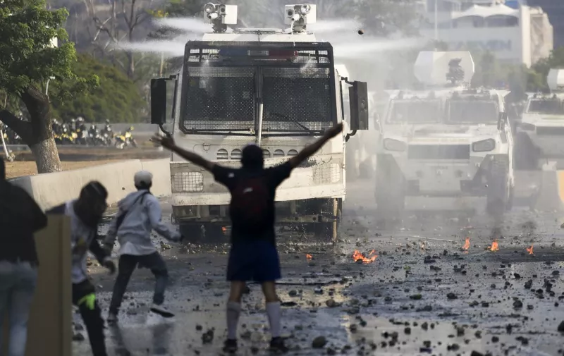 Anti-government protesters clash with security forces in Caracas during the commemoration of May Day on May 1, 2019. - Opposition supporters demonstrated for a second consecutive day in support of their country's self-proclaimed leader Juan Guaido as he bids to overthrow President Nicolas Maduro. Maduro and his government have vowed to put down what they see as an attempted coup by the US-backed opposition leader. (Photo by CRISTIAN HERNANDEZ / AFP)