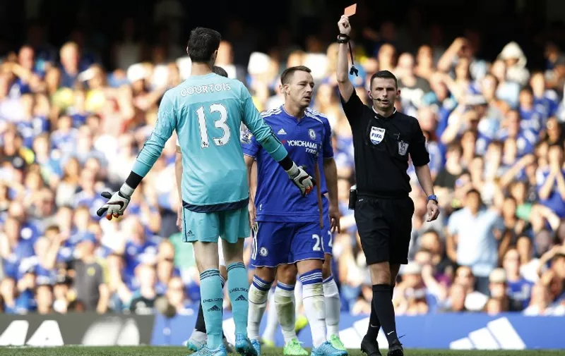 Referee Michael Oliver (R) shows the red card to send off Chelsea's Belgian goalkeeper Thibaut Courtois (L) after a foul on Swansea City's French striker Bafetimbi Gomis (unseen) conceeded a penalty as Chelsea's English defender John Terry (C) reacts during the English Premier League football match between Chelsea and Swansea City at Stamford Bridge in London on August 8, 2015. AFP PHOTO / ADRIAN DENNIS

RESTRICTED TO EDITORIAL USE. No use with unauthorized audio, video, data, fixture lists, club/league logos or 'live' services. Online in-match use limited to 75 images, no video emulation. No use in betting, games or single club/league/player publications.