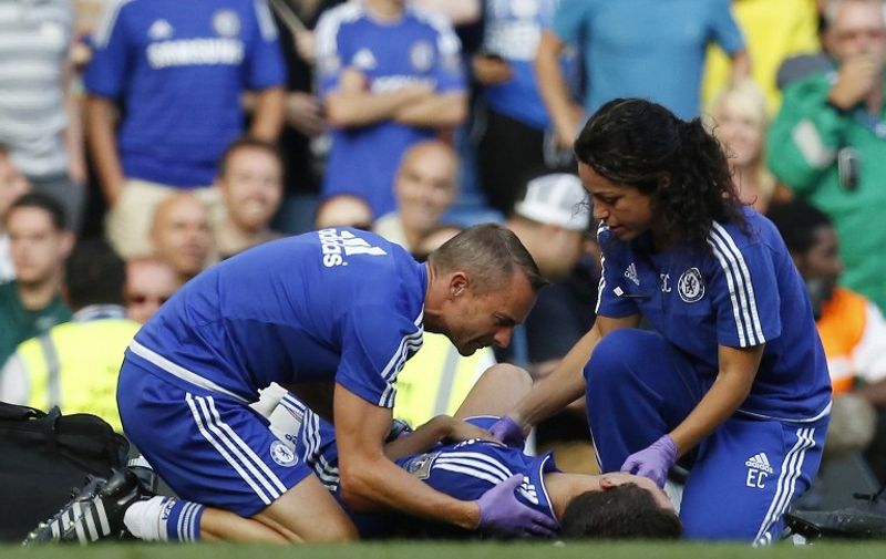 Chelsea doctor (R) Eva Carneiro and head physio Jon Fearn (L) treat Chelsea's Belgian midfielder Eden Hazard late on during the English Premier League football match between Chelsea and Swansea City  at Stamford Bridge in London on August 8, 2015. Chelsea have sidelined team doctor Eva Carneiro from match-day duties after she fell foul of manager Jose Mourinho, according to British media reports on August 11, 2015. Mourinho criticised Carneiro after she ran on the pitch to treat Eden Hazard in stoppage time of Chelsea's 2-2 draw at home to Swansea City on August 8, saying she did not "understand the game". AFP PHOTO / IAN KINGTON

RESTRICTED TO EDITORIAL USE. No use with unauthorized audio, video, data, fixture lists, club/league logos or 'live' services. Online in-match use limited to 75 images, no video emulation. No use in betting, games or single club/league/player publications.