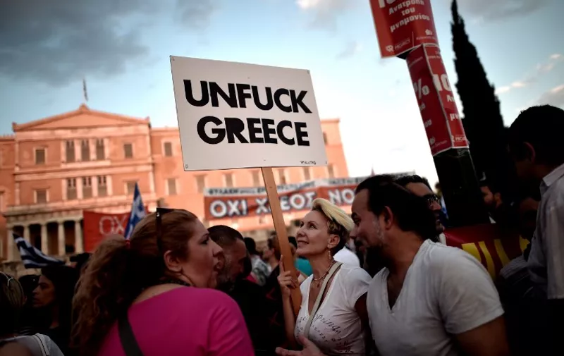 Protesters participate a demonstration in front of the Greek parliament in Athens on June 29, 2015. Greece shut its banks and the stock market and imposed capital controls after creditors at the weekend refused to extend the country's bailout past the June 30 deadline, prompting anxious citizens to empty ATMs. AFP PHOTO / ARIS MESSINIS
