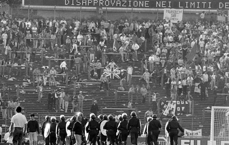 (FILES) A file photo taken on May 29, 1985 shows Belgium policemen facing British fans at Heysel football stadium in Brussels. May 29 marks the 30th anniversary of the day 39 people died when a wall collapsed after Liverpool fans charged their Juventus counterparts prior to the 1985 European Cup final at the run-down Heysel Stadium. AFP PHOTO / DOMINIQUE FAGET