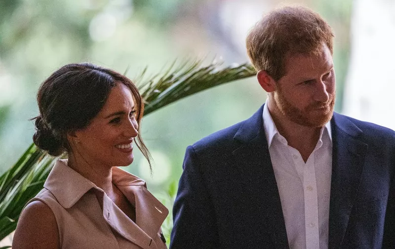 Britain's Prince Harry, Duke of Sussex(R) and Meghan, the Duchess of Sussex(L) stand on the stage at the British High Commissioner residency in Johannesburg where they  will meet with Graca Machel, widow of former South African president Nelson Mandela, in Johannesburg, on October 2, 2019. - Prince Harry recalled the hounding of his late mother Diana to denounce media treatment of his wife Meghan Markle, as the couple launched legal action against a British tabloid for invasion of privacy. (Photo by Michele Spatari / AFP)