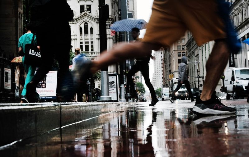 NEW YORK, NEW YORK - JUNE 16: People cross over to Wall Street in the rain on June 16, 2022 in New York City. Stocks fell sharply in morning trading as investors react to the Federal Reserve's largest rate hike since 1994.   Spencer Platt/Getty Images/AFP (Photo by SPENCER PLATT / GETTY IMAGES NORTH AMERICA / Getty Images via AFP)