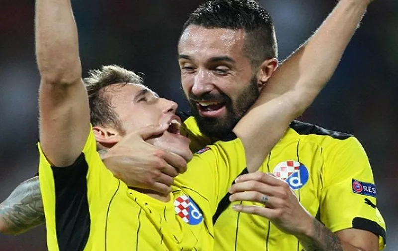 Jeremy Taravel (R) and Josip Pivaric of Dinamo Zagreb celebrate after scoring the second goal during the UEFA Champions League playoff football match between KF Skenderbeu and Dinamo Zagreb at the Elbansan Arena in Elbasan, Albania on August 19, 2015. Dinamo Zagreb won the match 1-2. AFP PHOTO / GENT SHKULLAKU