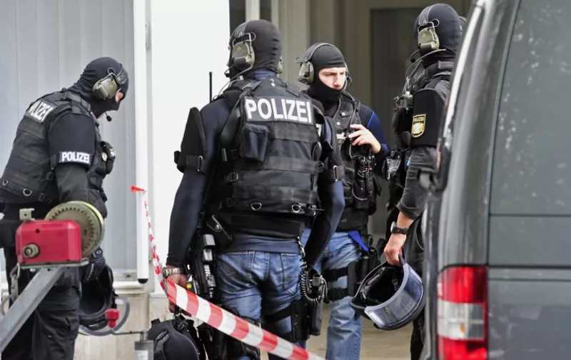 German special police forces arrive at a hostage situation in the townhall in Ingolstadt, southern Germany, on August 19, 2013. A man claiming to be armed took several hostages in the town hall. According to local media, the hostage taker was thought to be a 23-year-old escapee from a nearby psychiatric ward, armed with a handgun, who had been stalking a female town hall employee, 25. A planned election campaign event with German Chancellor Angela Merkel that was scheduled in Ingolstadt later in the day was cancelled.      AFP PHOTO / LENNART PREISS