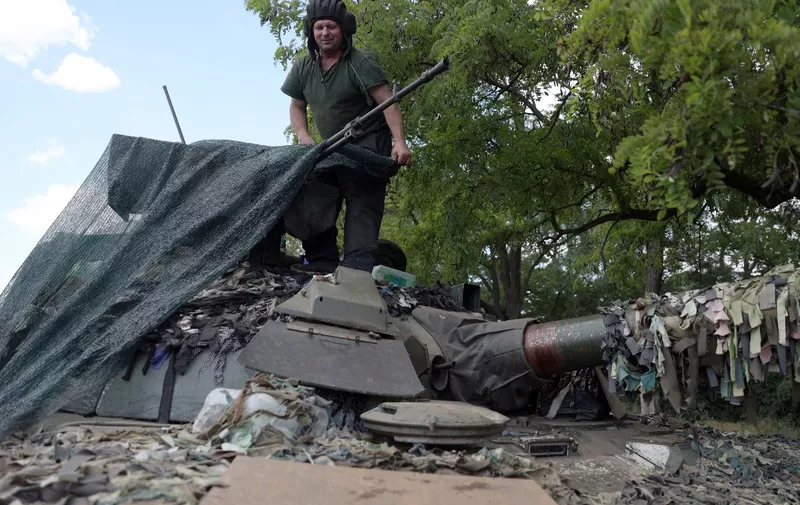 A Ukrainian serviceman covers the turret of an tank in the eastern Ukrainian region of Donbas on June 21, 2022, as Ukraine says Russian shelling has caused "catastrophic destruction" in the eastern industrial city of Lysychansk, which lies just across a river from Severodonetsk where Russian and Ukrainian troops have been locked in battle for weeks. - Regional governor Sergiy Gaiday says that non-stop shelling of Lysychansk on June 20 destroyed 10 residential blocks and a police station, killing at least one person. (Photo by Anatolii Stepanov / AFP)