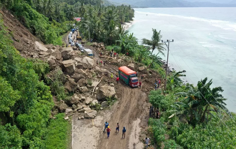 This aerial picture shows motorists waiting in a queue to pass through a section of road affected by a landslide caused by a 6.2 magnitude earthquake in Majene, West Sulawesi on January 19, 2021. (Photo by ADEK BERRY / AFP)