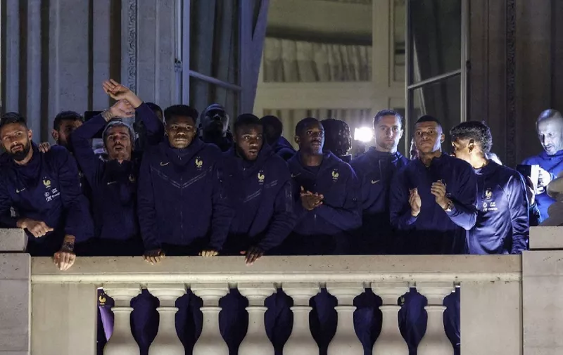 (FROM L) France's forward Olivier Giroud, France's forward Antoine Griezmann, France's midfielder Aurelien Tchouameni, France's defender Dayot Upamecano, France's forward Ousmane Dembele, France's midfielder Adrien Rabiot, France's forward Kylian Mbappe, France's forward Kingsley Coman greet supporters at the Hotel de Crillon, a day after the Qatar 2022 World Cup final match against Argentina, at the Place de la Concorde in central Paris on December 19, 2022. (Photo by Geoffroy Van der Hasselt / AFP)
